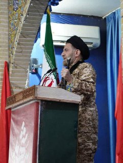 Имам Хоррамдабада с автоматом на проповеди