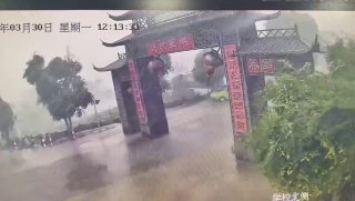 Китаец едва не погиб под рухнувшими от урагана воротами