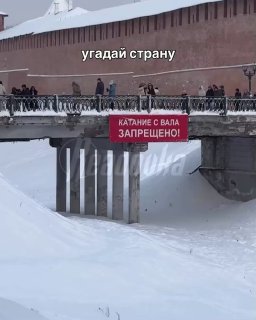 Дети катаются с кремлевских валов в Великом Новгороде, невзирая на огромное запрещающее полотно